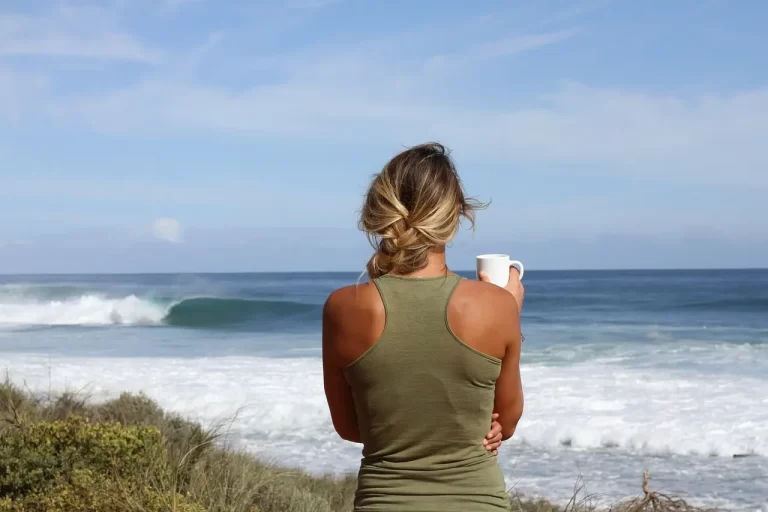 Mujer bebiendo café en el mar